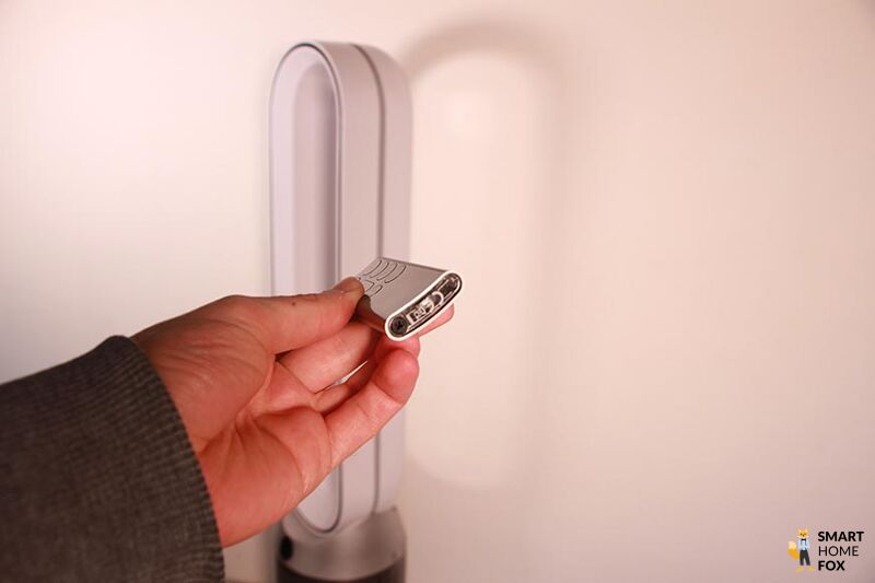 Die kleine und gebogene Fernbedienung vom Dyson Purifier Cool Autoreact TP7A Luftreinigers wird in der Hand gehalten